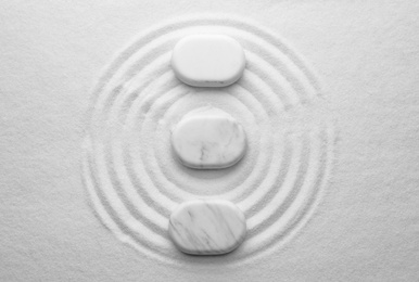 White stones on sand with pattern, flat lay. Zen, meditation, harmony