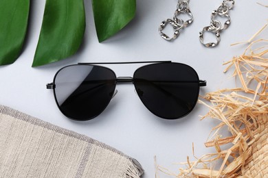 New stylish sunglasses and earrings on white background, flat lay