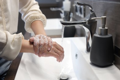 Woman washing hands in bathroom, closeup view