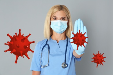 Stop Covid-19 outbreak. Doctor wearing medical mask surrounded by virus on light background