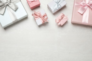 Beautiful gift boxes on white table, flat lay. Space for text