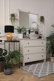 Stylish bathroom interior with modern furniture and beautiful houseplants