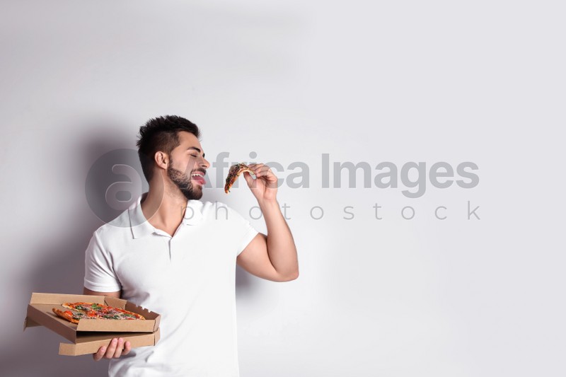 Photo of Handsome man with pizza on white background, space for text