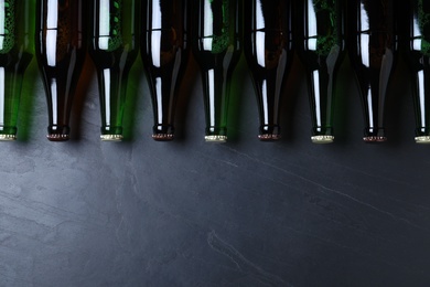 Photo of Bottles of beer on grey table, flat lay. Space for text