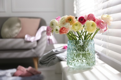 Beautiful ranunculus flowers in vase on window sill indoors, space for text