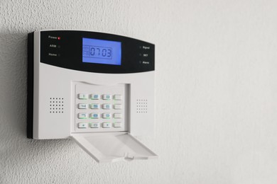 Home security system on white wall indoors, space for text