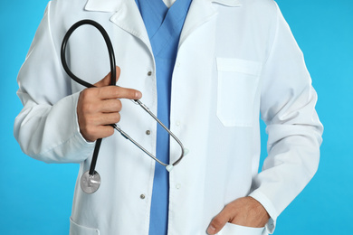 Doctor with stethoscope on blue background, closeup
