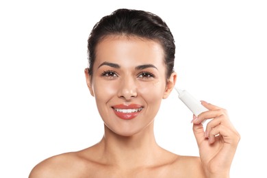 Woman applying cream under eyes on white background. Skin care