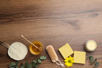 Flat lay composition with beeswax and cosmetic products on wooden table. Space for text