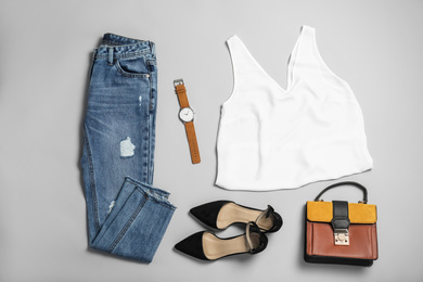 Stylish outfit with jeans on light grey background, flat lay