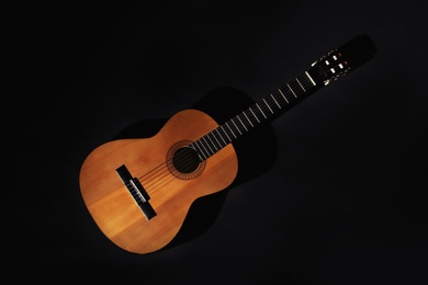 Acoustic guitar on black background, top view. Musical instrument