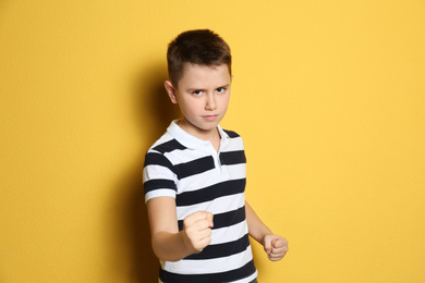 Portrait of emotional preteen boy on yellow background