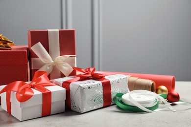 Beautiful Christmas gift boxes wrapped in paper and decorated with bows on light table