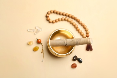 Flat lay composition with golden singing bowl on beige background. Sound healing