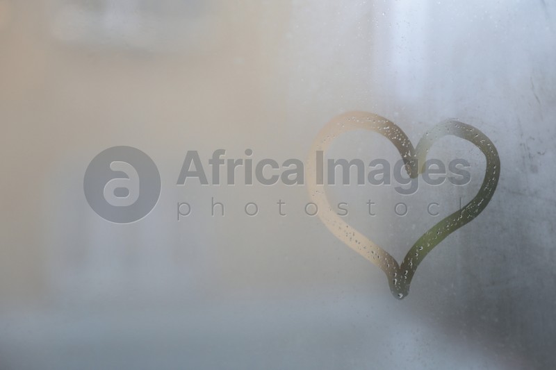 Heart drawn on foggy window, space for text. Rainy weather