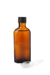Photo of Bottle of syrup with plastic spoon on white background. Cough and cold medicine