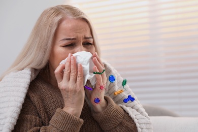 Mature woman suffering from cold at home. Microbes spreading