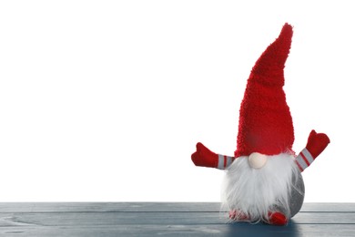 Funny Christmas gnome on blue wooden table against white background. Space for text