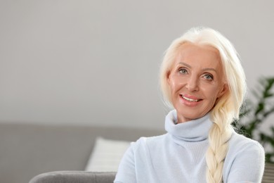 Portrait of happy mature woman at home. Space for text