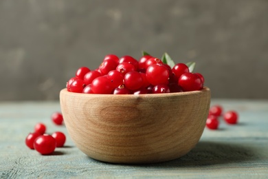 Tasty ripe cranberries on light blue wooden table, closeup