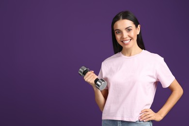 Photo of Woman with dumbbell as symbol of girl power on purple background, space for text. 8 March concept