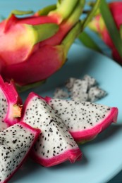 Plate with delicious cut and whole white pitahaya fruits, closeup