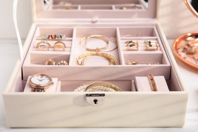 Jewelry box with stylish golden bijouterie on white table