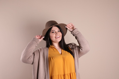 Beautiful overweight woman posing on beige background. Plus size model
