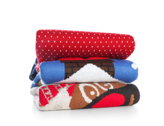 Photo of Stack of warm Christmas sweaters isolated on white