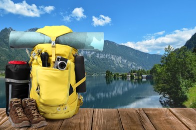 Camping equipment for tourist on wooden surface and beautiful view of mountain landscape
