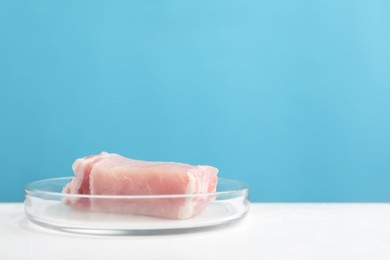 Photo of Lab grown meat in Petri dish on white table. Space for text