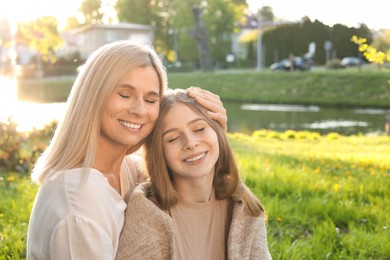 Photo of Happy mother with her daughter spending time together in park on sunny day