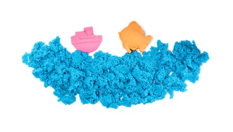 Ship, fish and sea made of kinetic sand on white background, top view