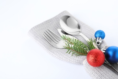 Cutlery, napkin and Christmas decor on white background, closeup. Festive table setting