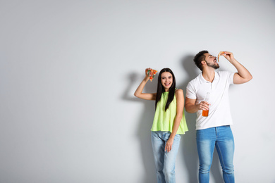 Happy couple with pizza and beer on white background, copy space text