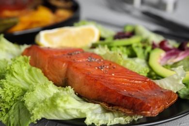 Photo of Tasty cooked salmon and fresh salad on plate, closeup. Healthy meals from air fryer