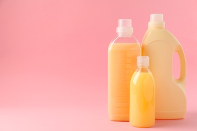 Photo of Bottles of laundry detergents on pink background. Space for text