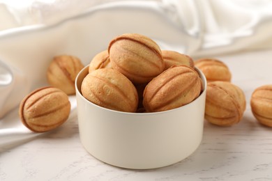 Photo of Delicious nut shaped cookies on white wooden table, closeup