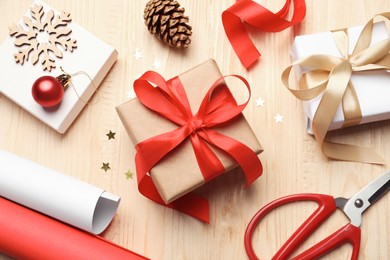 Flat lay composition with beautiful Christmas gift boxes and wrapping paper on wooden table