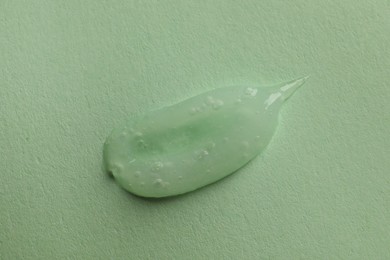 Photo of Sample of face gel on light green background, top view