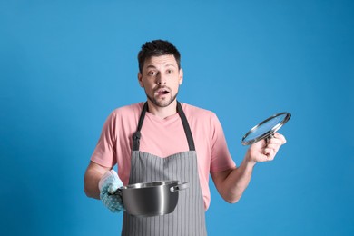 Surprised man with pot on light blue background