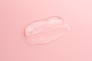 Sample of transparent gel on pink background, top view