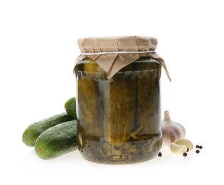 Jar of pickled cucumbers and fresh ingredients on white background
