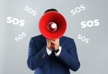 Man with megaphone and words SOS on grey background. Asking for help