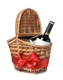 Festive basket with bottle of wine and gift on white background