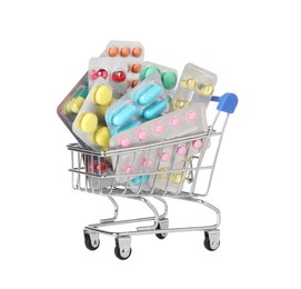Blisters with different pills in mini shopping cart on white background