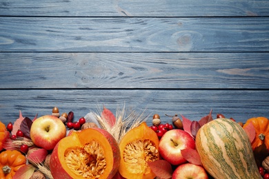 Flat lay composition with vegetables, fruits and autumn leaves on blue wooden table, space for text. Thanksgiving Day