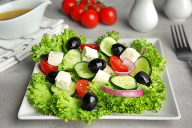 Tasty fresh Greek salad on grey table