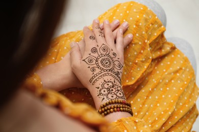 Woman with beautiful henna tattoo on hand, above view. Traditional mehndi