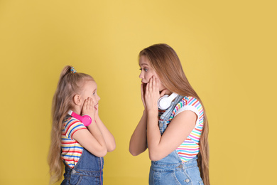 Emotional mother and daughter on yellow background